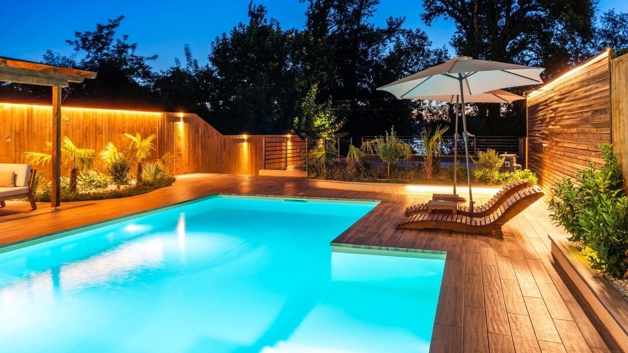 Forbes Fab Luxe swimming pool illuminated at night with lounge chairs