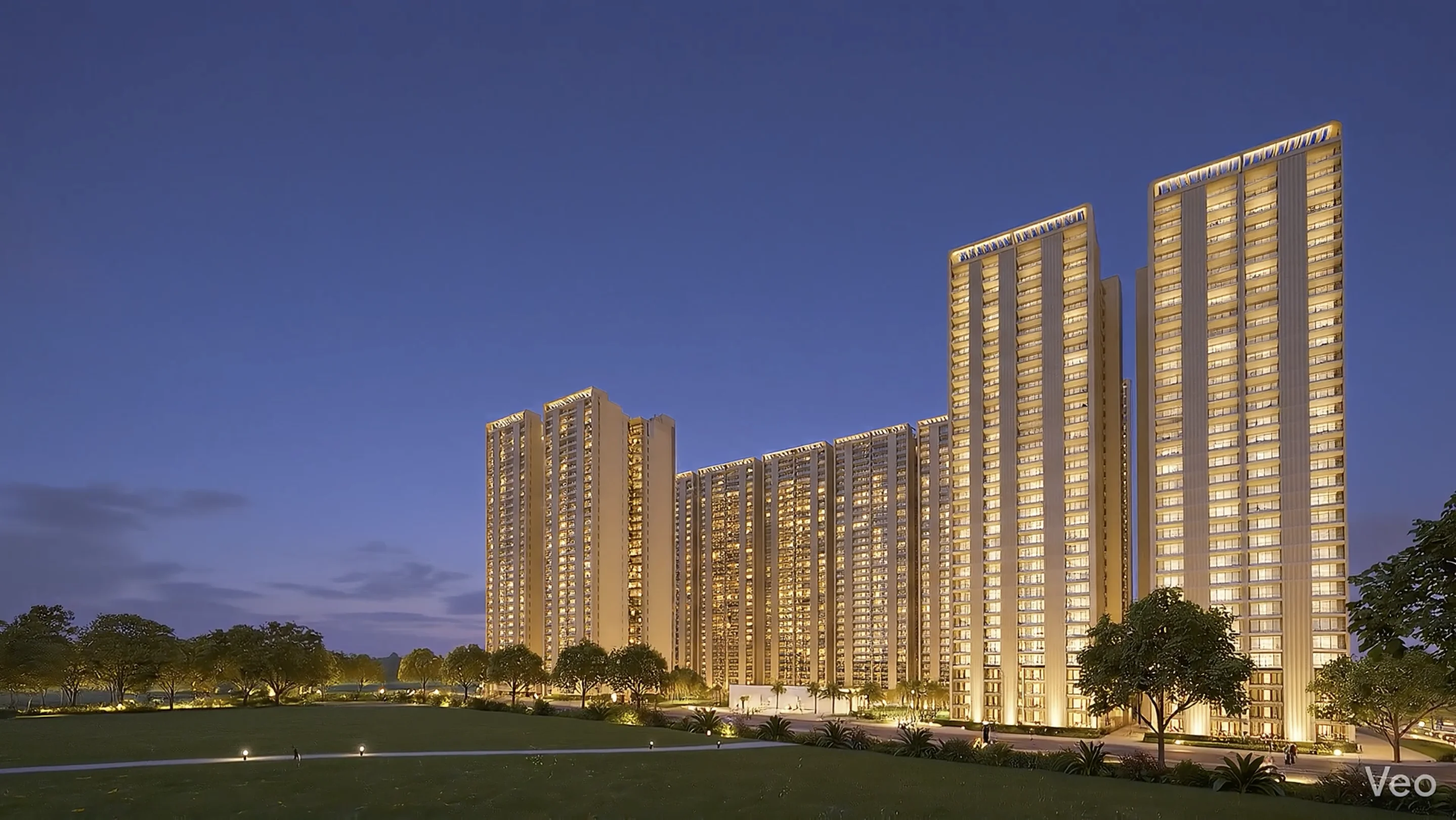 Forbes Fab Luxe Residences tower cluster at dusk with warm golden lighting and landscaped lawn